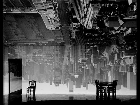 Black and white image of Manhattan skyline inverted and projected into a darkened room with table and chairs