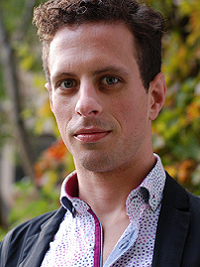 faculty headshot of man with pattered shirt and blue blazer