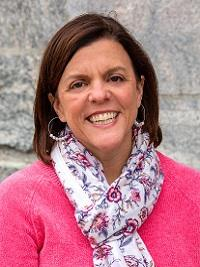 headshot of meg fox kelly chaplain's office woman with dark hair and pink sweater