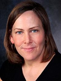 close image of female faculty member with medium brown hair to her shoulders with a dark colored top
