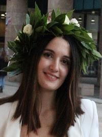 dark hair smiling student with a wreath on