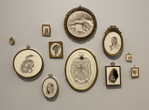 A series of small antique frames with drawings and portraits made with human hair.