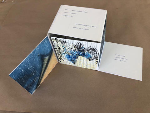 Artists’ collaborative book in a fold-out square shape, with text and images relating to the poem At the Edge of the Ocean by poet Susan Roney-O’Brien.