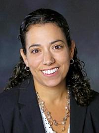 lauren capotosto, picture of a woman with long black hair pulled back wearing a black blazer smiling at the camera