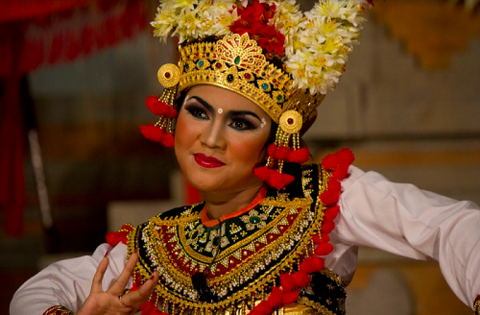 A Balinese performer wearing beautifully ornate and colorful clothing.