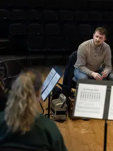 Students and faculty receive a lesson in playing the Irish penny whistle from visiting Irish musician Diarmuid Ó Meachair
