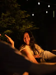 Students participate in an orientation event next to an outdoor fire.