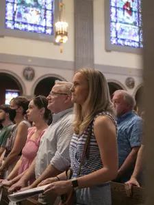 a family standing in a pew in St. Joseph Memorial Chapel