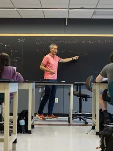 Professor Narita teaching in front of a classroom