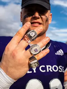 A Holy Cross football player shows off their championship rings