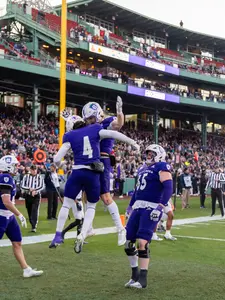 Holy Cross football players celebrate a touchdown during a game played at Fenway Park.