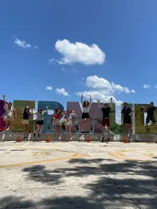 Students pose in front of a sign reading Bermuda