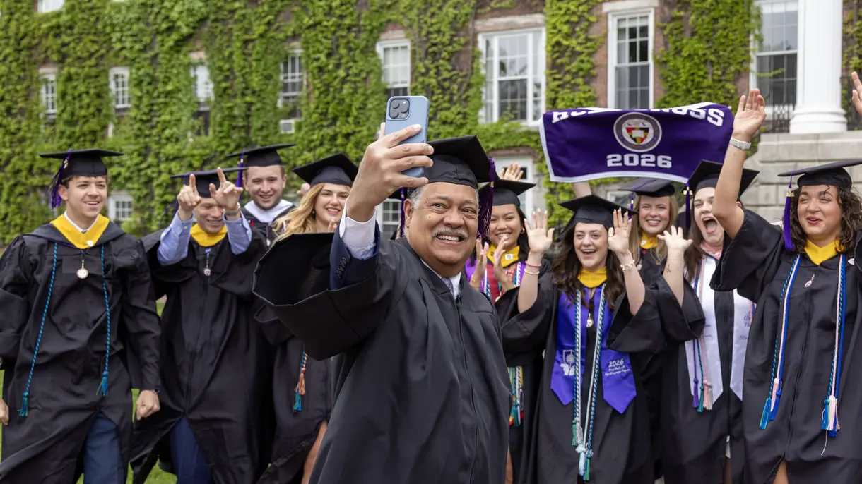 President Rougeau taking a selfie with graduates in front of Fenwick Hall