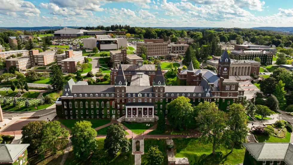 Photo taken from the sky above a college campus showing lots of green space and old brick buildings.