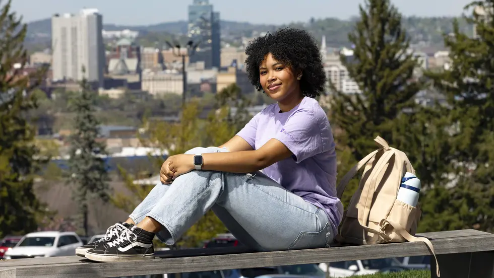 Bobbie Pitts sits on an bench on campus 