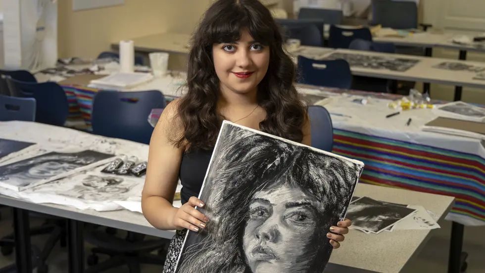 Sophie Sundaram &#039;26 holding a portrait
