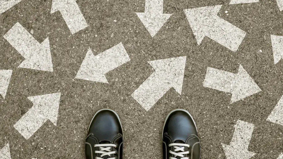 Pair of feet on a road with arrows