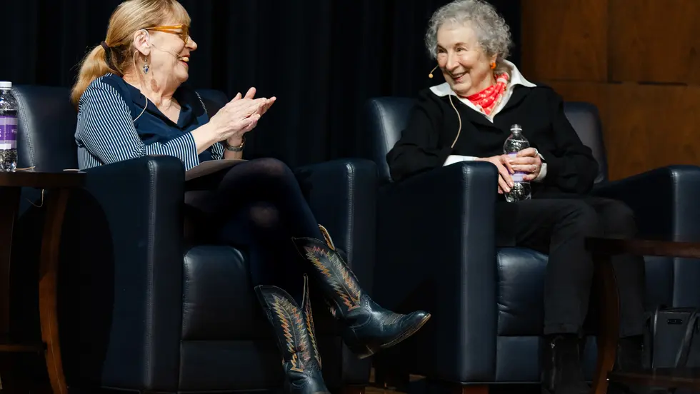 Two women sit in chairs talking