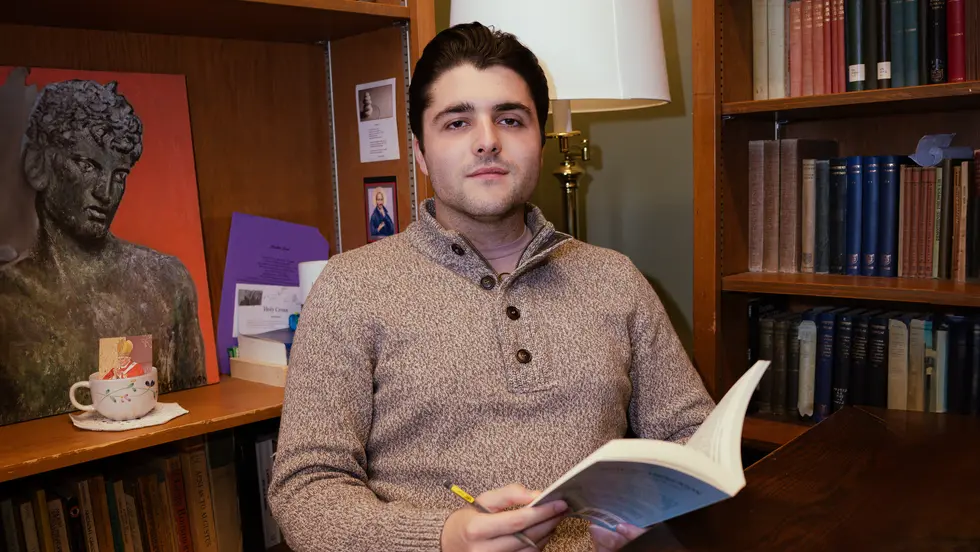 Young man with book at desk