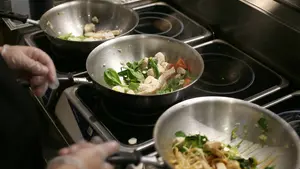 stir fry pans filled with noodles and vegetables