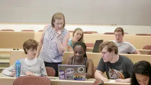 Spanish students and professor working on a project in a classroom together.
