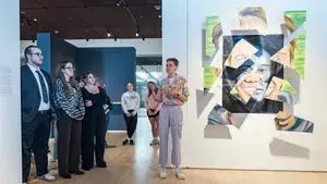 Student presenting their art for senior art exhibition in Cantor Art Gallery.