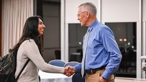 A students and professor shake hands
