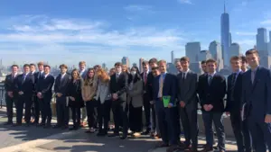 Students in the finance and banking certificate program stand in front of the New York City skyline