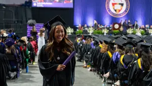 A student receives their diploma at Holy Cross commencement 2026
