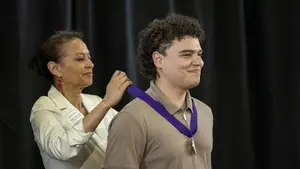 A graduating student is presented with a medal at the 2026 Holy Cross awards ceremony