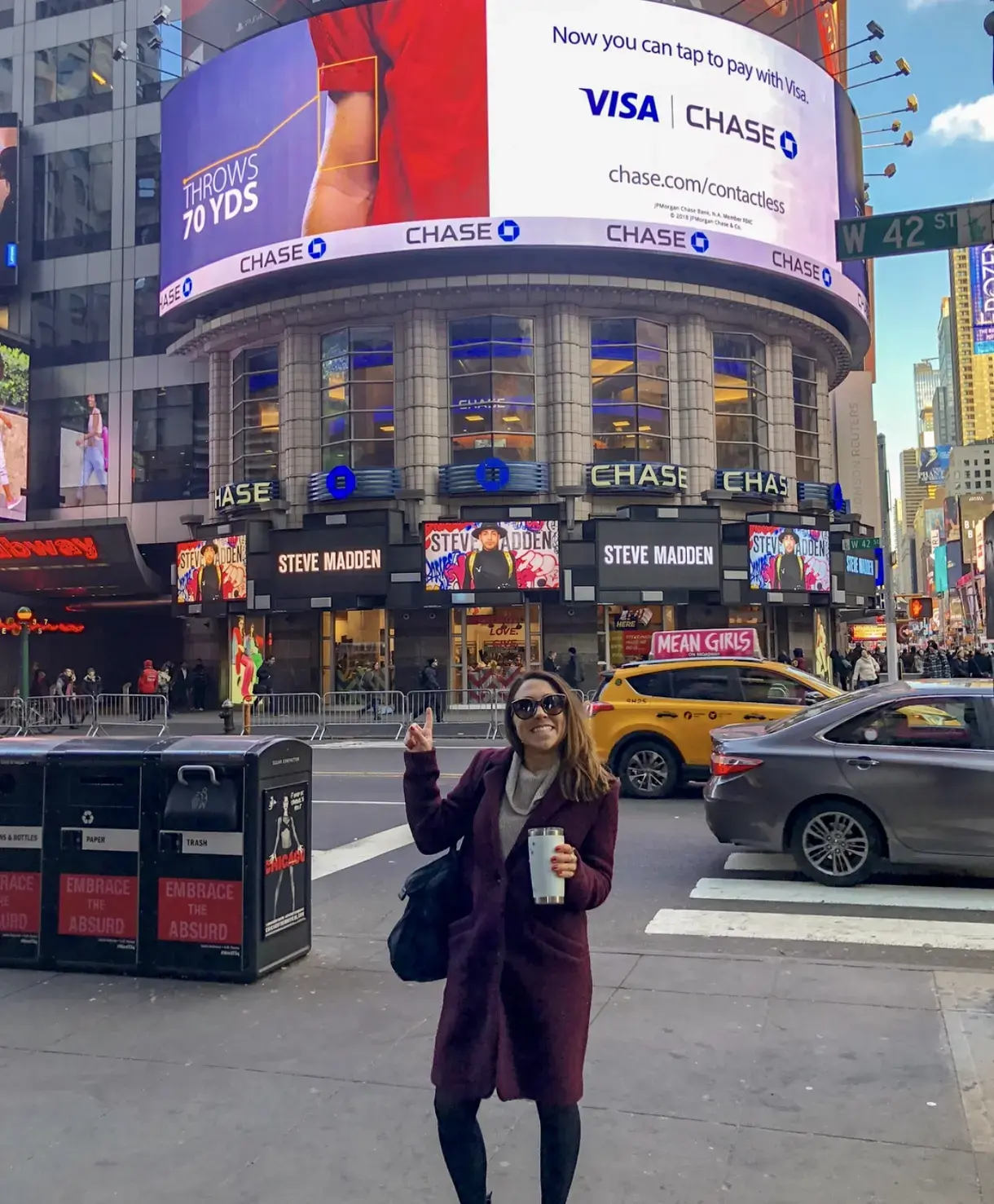 Gina Righini Cipolla poses in front of a billboard in Times Square.